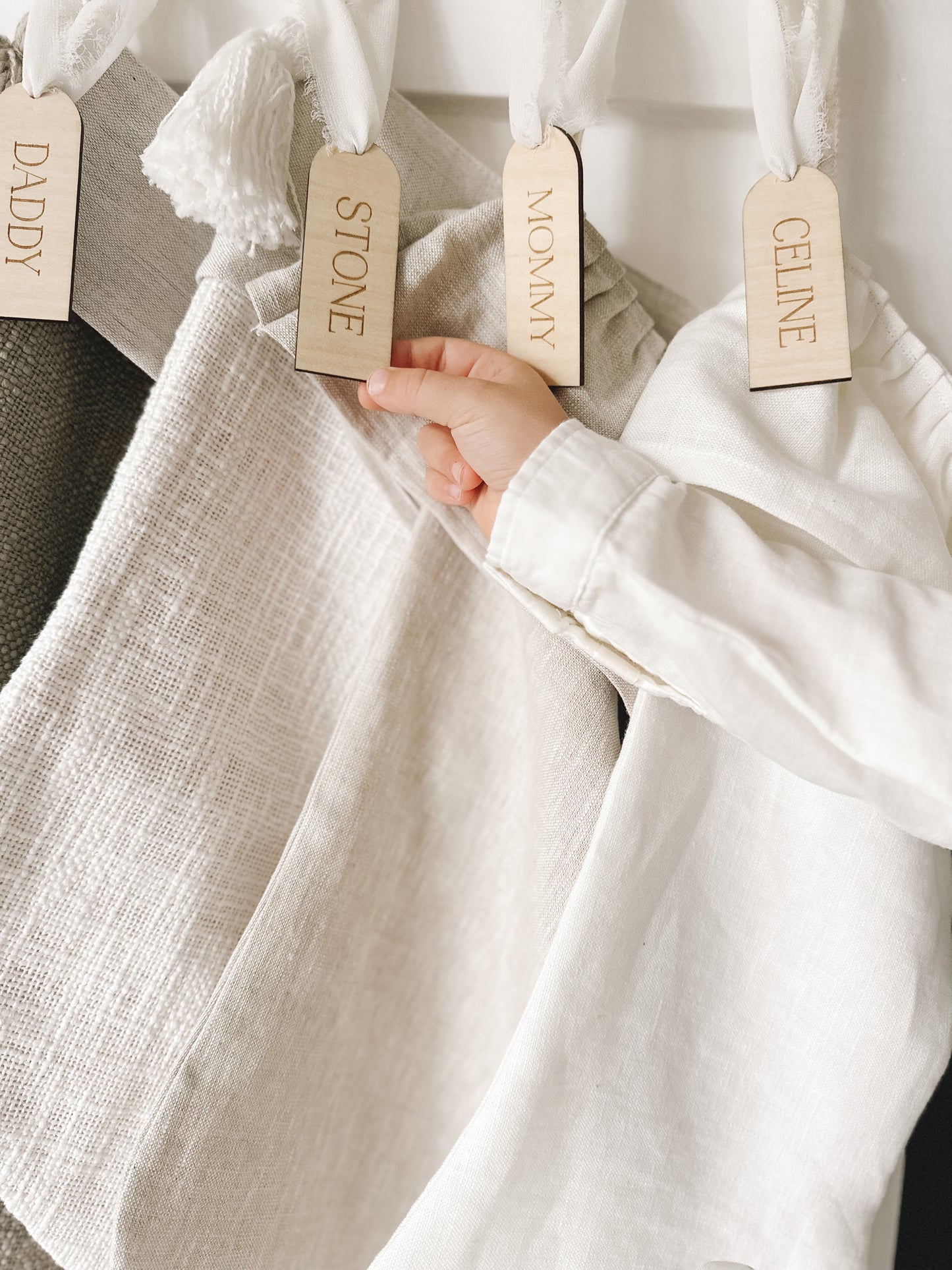 custom wooden christmas tag hanging on stockings above fireplace