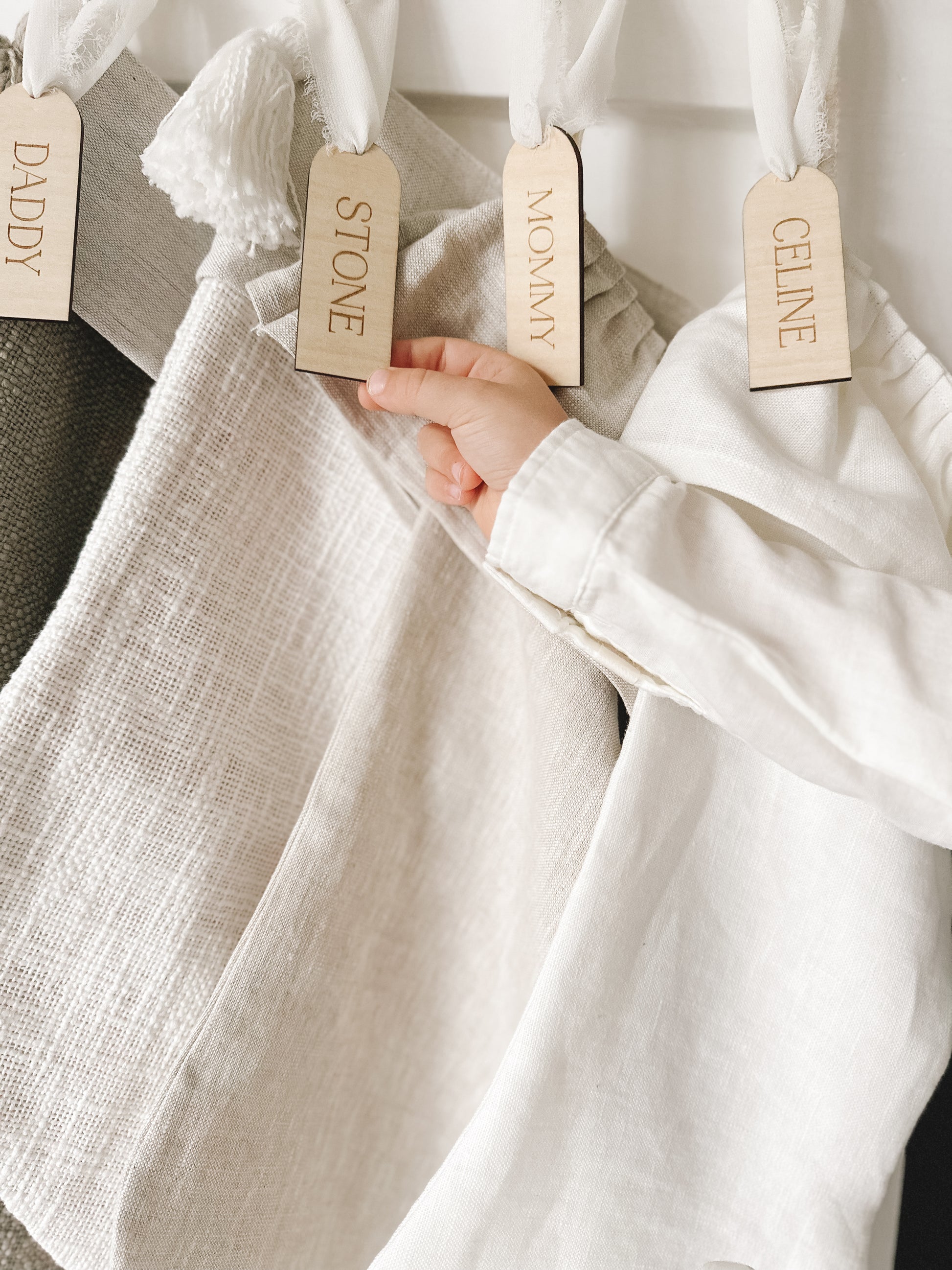 custom wooden christmas tag hanging on stockings above fireplace